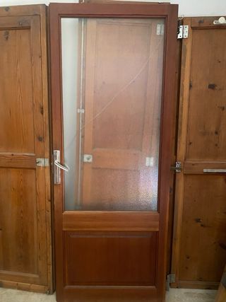 Puerta de madera con cristal y una de aluminio
