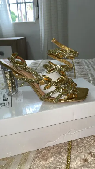 Sandalias doradas con pedrería y tacón