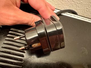 Microondas Negro con adaptador para enchufe.