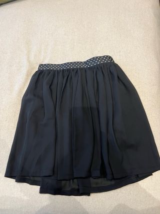 Falda negra suelta por encima de la rodilla