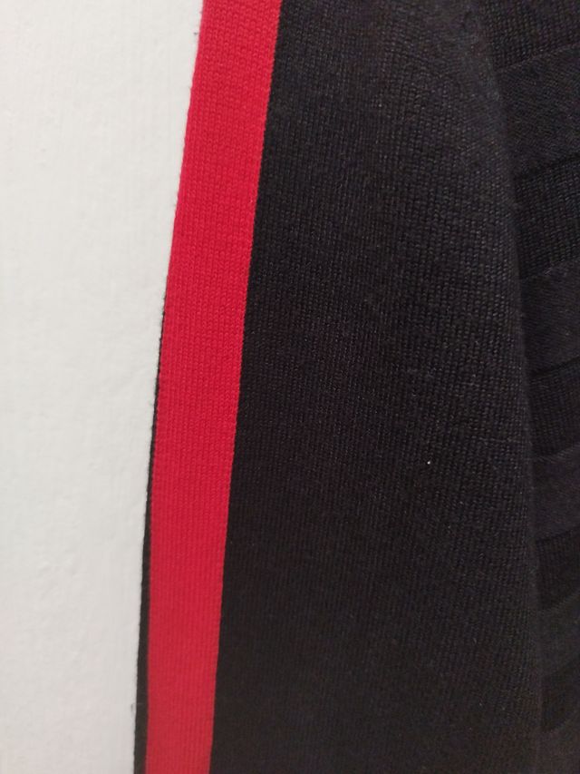 Jersey negro cuello alto con rayas rojas