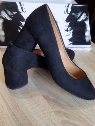 Zapatos de tacón negros ante mujer