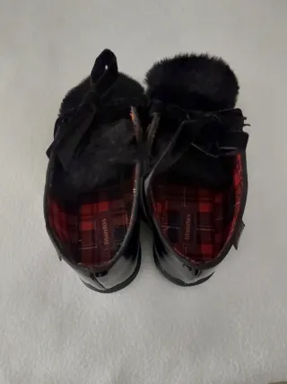 Zapatos negros de charol con flecos y lazo