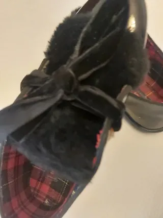 Zapatos negros de charol con flecos y lazo