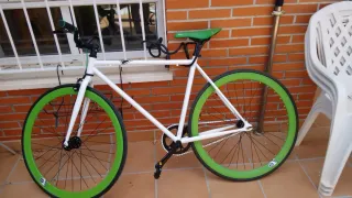 Bicicleta blanca con ruedas verdes para ciudad.