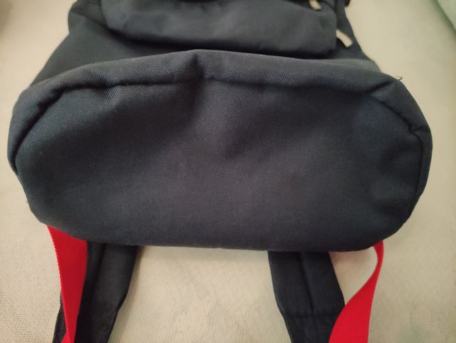 Mochila azul con tiras rojas.