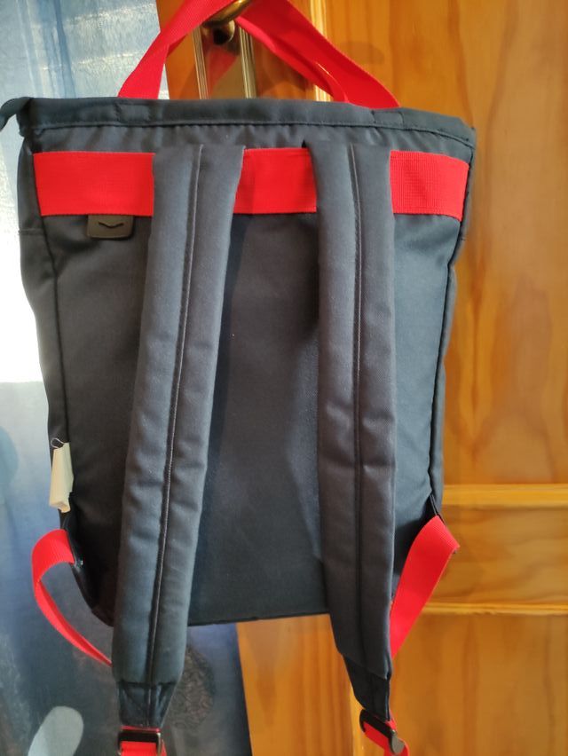 Mochila azul con tiras rojas.