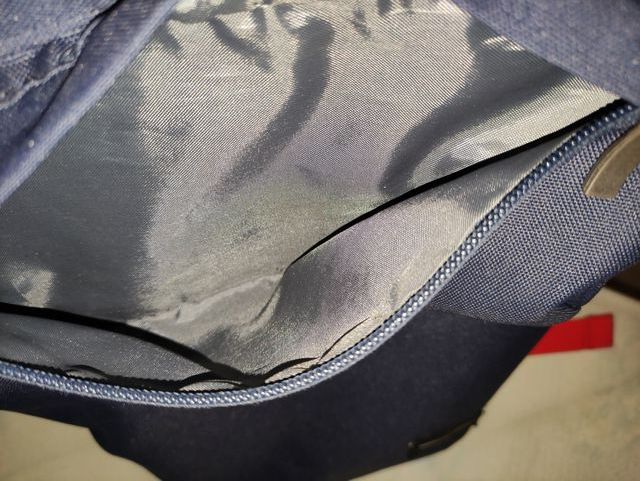 Mochila azul con tiras rojas.