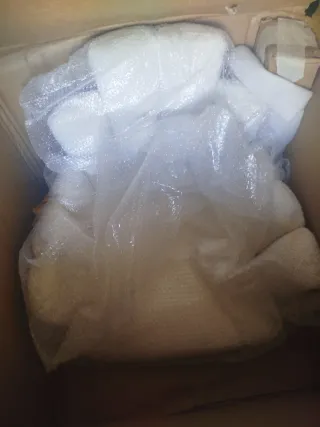 Sillón blanco estilo concha con patas doradas.