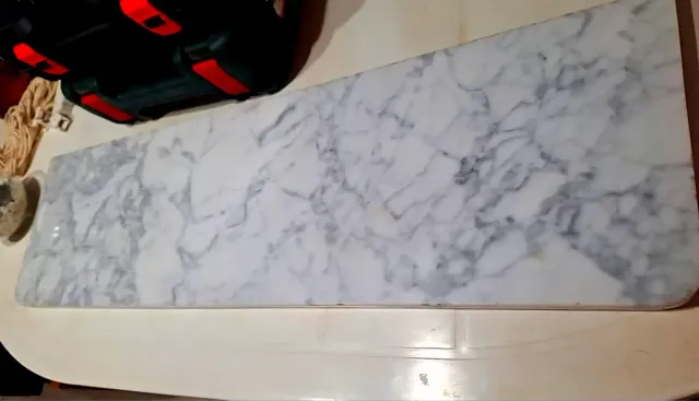 Soporte estabteria de mármol blanco y gris.