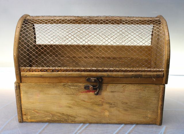 Peito, pequeno baú de madeira com tampo em malha.