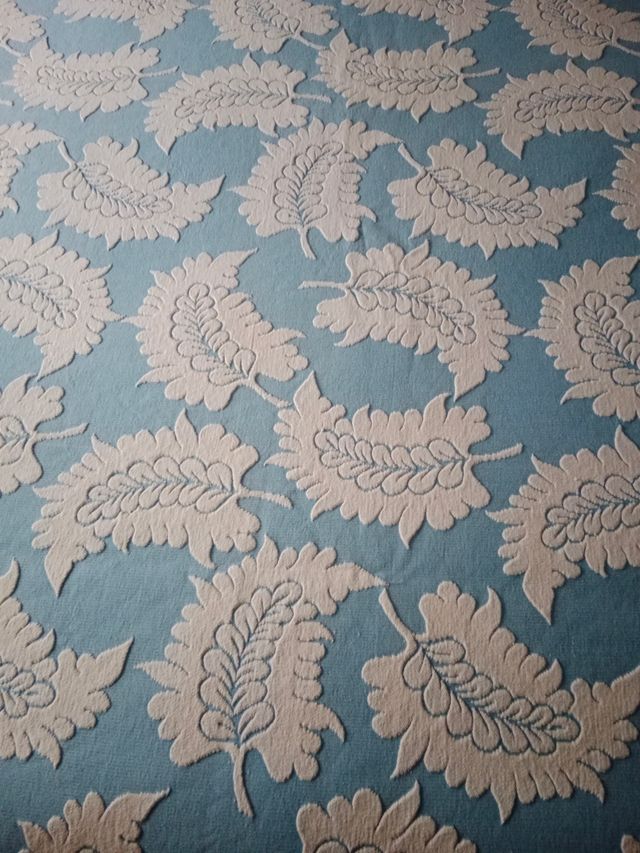 Colcha azul y blanca con diseño floral