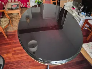 Mesa de comedor ovalada negra con detalles dorados