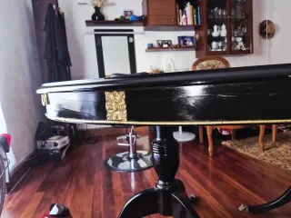 Mesa de comedor ovalada negra con detalles dorados