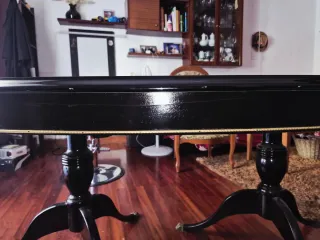 Mesa de comedor ovalada negra con detalles dorados