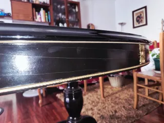 Mesa de comedor ovalada negra con detalles dorados