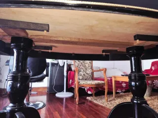 Mesa de comedor ovalada negra con detalles dorados