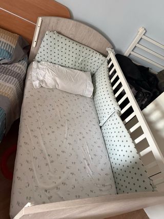 Cuna con ropa de cama y protector