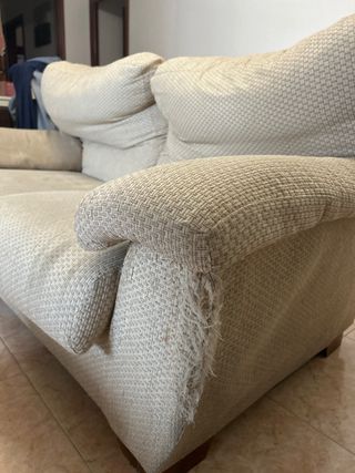 Sofá beige de tela con desperfectos