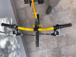 Bicicleta amarilla con rodillos de entrenamiento