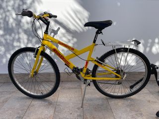 Bicicleta amarilla con rodillos de entrenamiento