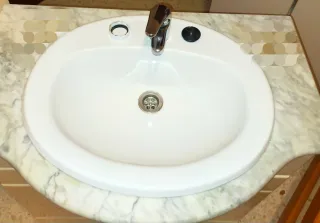 Mueble de baño con espejo, lavabo  y grifo 

