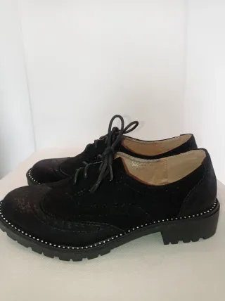 Zapatos negros con cordones y brillantes.