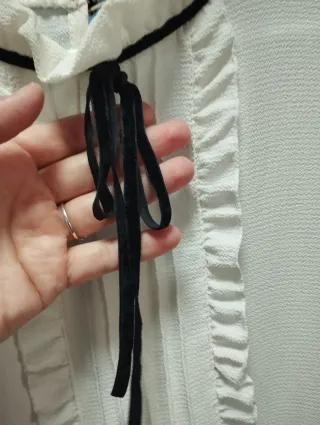 Blusa blanca con volantes y lazo negro