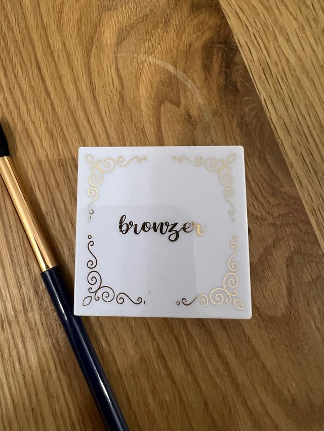 Bronceador y brocha dorada