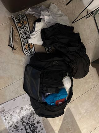 Maleta con ropa variada: camisetas, chaquetas....