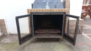 Chimenea de leña con puertas de cristal.