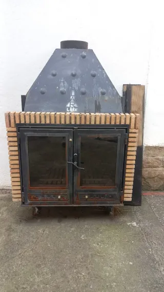 Chimenea de leña con puertas de cristal.