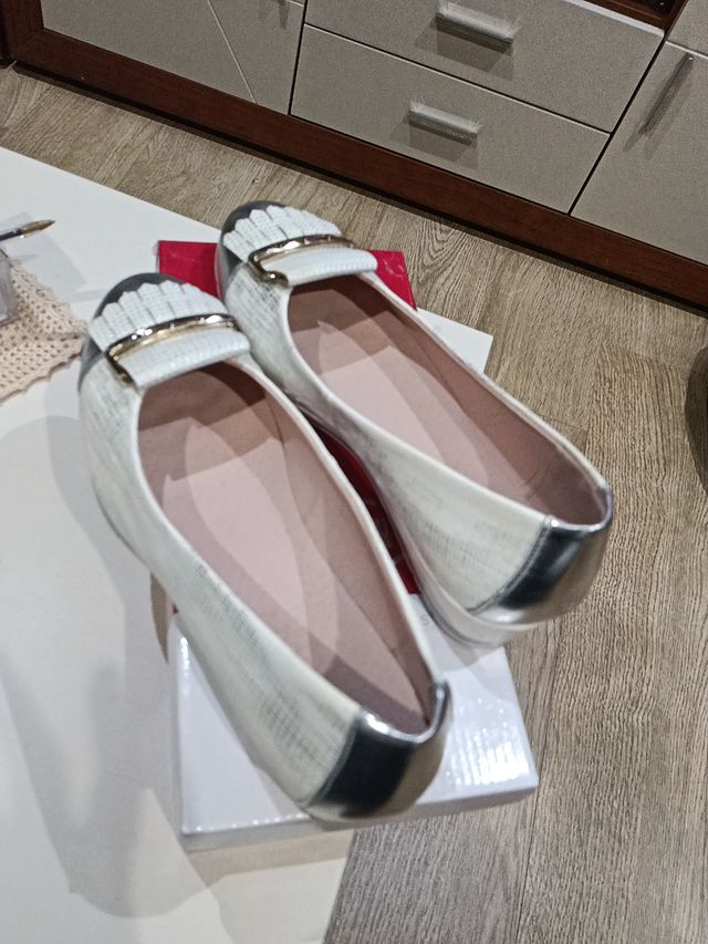 Zapatos planos plateados y blancos