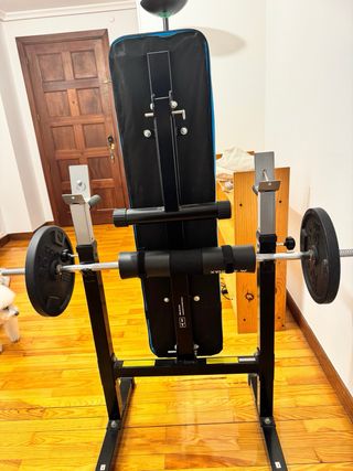 Banco de gimnasio con barra y discos