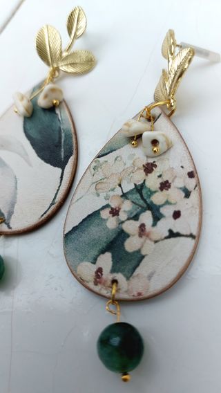 Pendientes dorados con hojas y piedras verdes