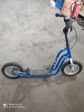 Patinete azul con ruedas grandes