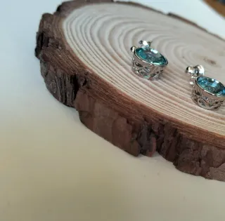 Pendientes plateados con cristal azul.