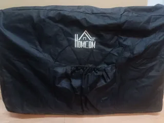 Camilla de masaje plegable naranja y negra.