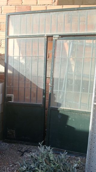 Puerta metálica con rejas y cristal