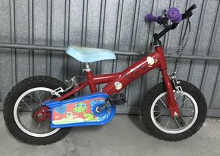 Bicicleta infantil roja con diseño de dinosaurios