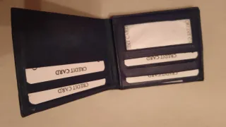 Cartera de piel negra con múltiples departamentos.