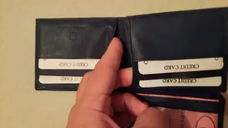 Cartera de piel negra con múltiples departamentos.