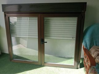 Ventana abatible con persiana marrón