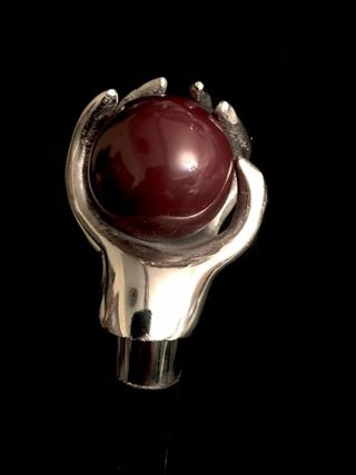 Bastón con empuñadura de mano sujetando una bola