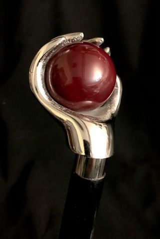 Bastón con empuñadura de mano sujetando una bola