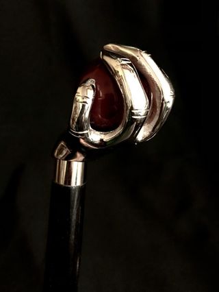 Bastón con empuñadura de mano sujetando una bola