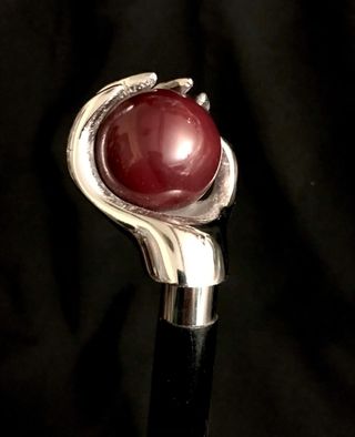 Bastón con empuñadura de mano sujetando una bola