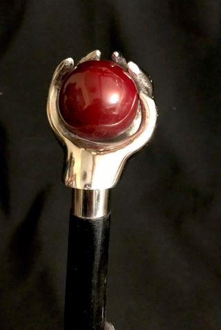 Bastón con empuñadura de mano sujetando una bola