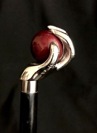 Bastón con empuñadura de mano sujetando una bola