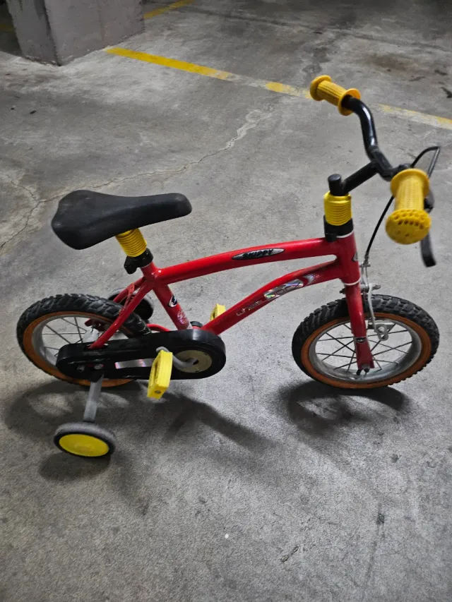 Bicicleta infantil roja con ruedines